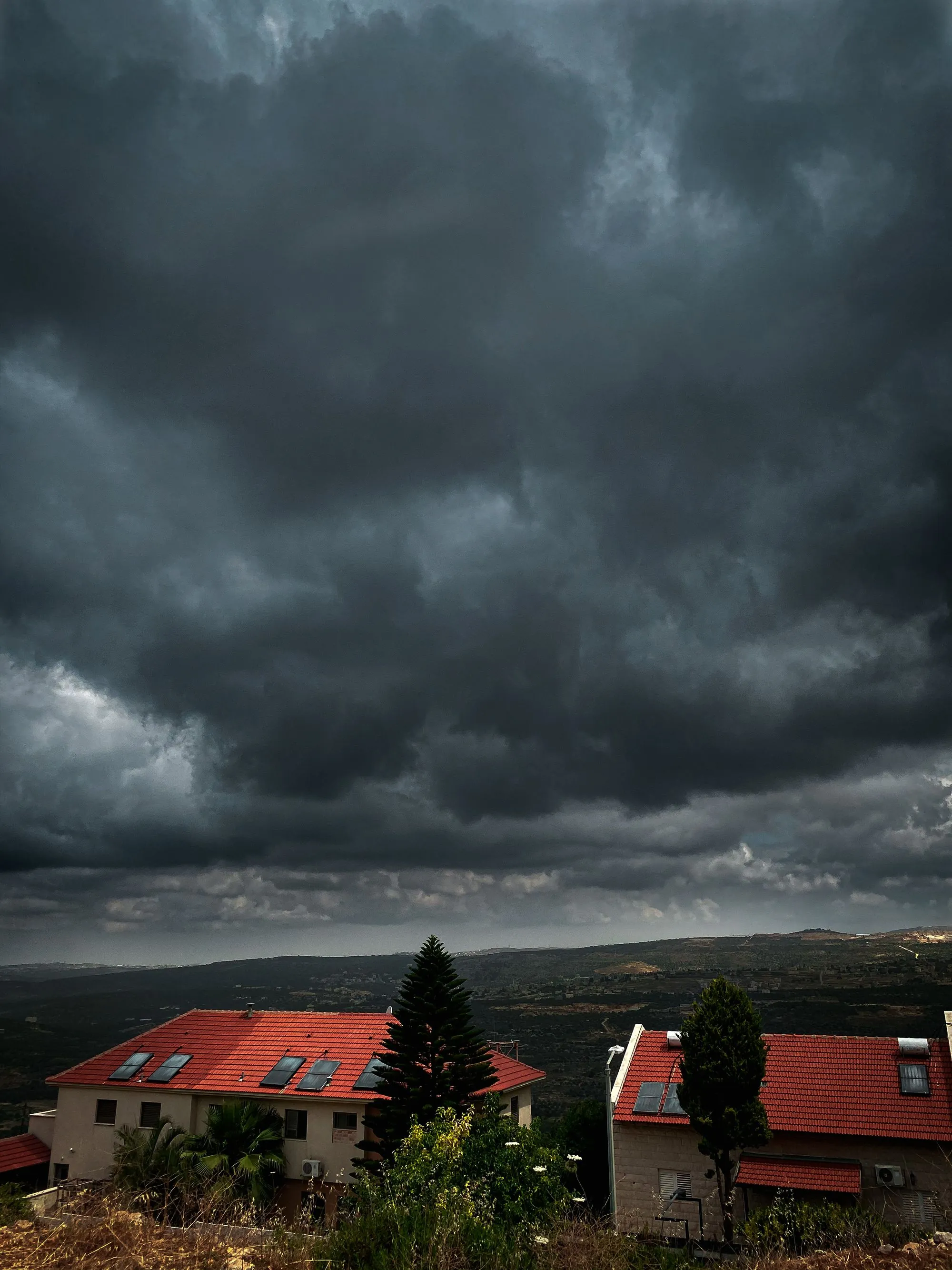 A heavy bank of storm cloud moving in low over open ground